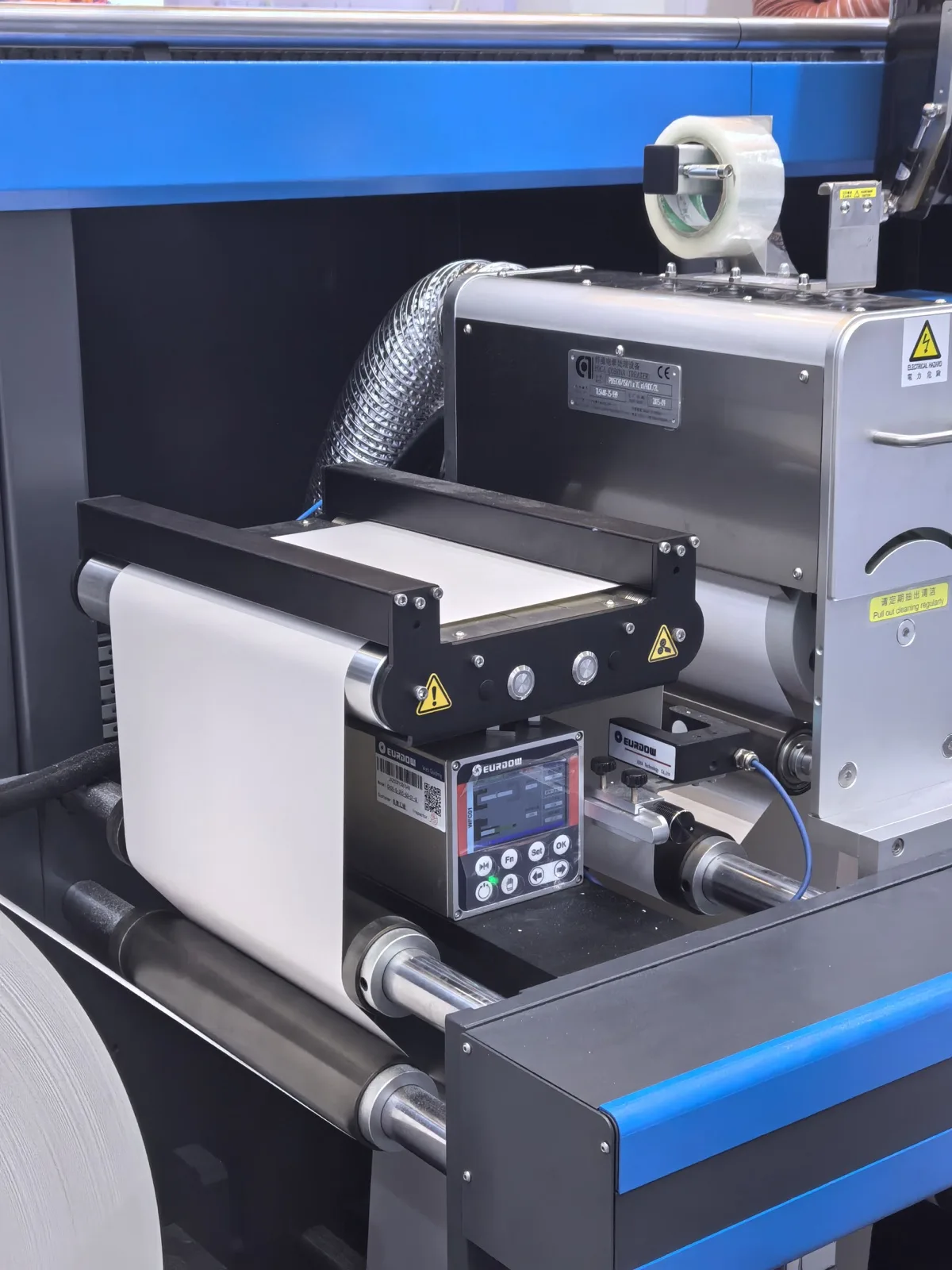 Integrated web guide carrying white label web on a blue converting machine